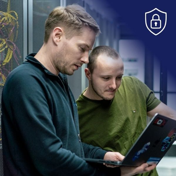Zwei Männer mit Laptop vor einem RACK im Rechenzentrum.